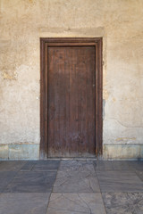 Fototapeta na wymiar Grunge wooden aged door on weathered stone wall