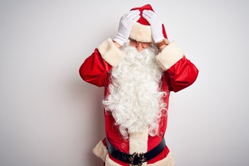 Middle age handsome man wearing Santa costume standing over isolated white background suffering from headache desperate and stressed because pain and migraine. Hands on head.
