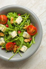 Fresh salad with tomatoes , blue cheese and nuts