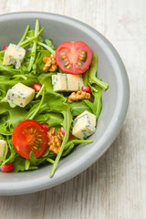 Fresh salad with tomatoes , blue cheese and nuts