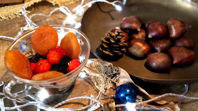 Video with portuguese chestnuts, traditional on christmas table. Flasher lights, white, used to illuminate and remind Christmas Eve. Dried fruits, apricot, chestnut and acerola as an option. Brazilian