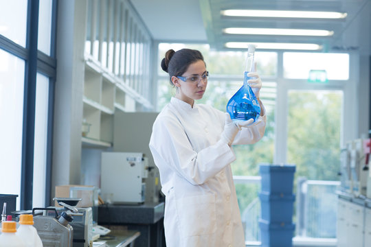 Young female scientist with glass bulb in a chemical lab