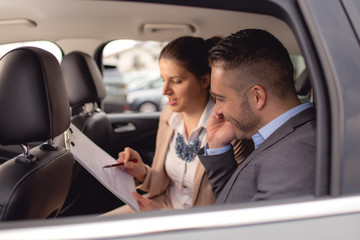 Young man buys a car on a car lot
