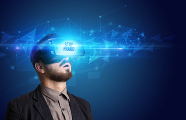 Businessman looking through Virtual Reality glasses with STOP FRAUD inscription, cyber security concept
