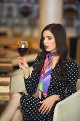 beautiful young woman with a glass of red wine in a restaurant