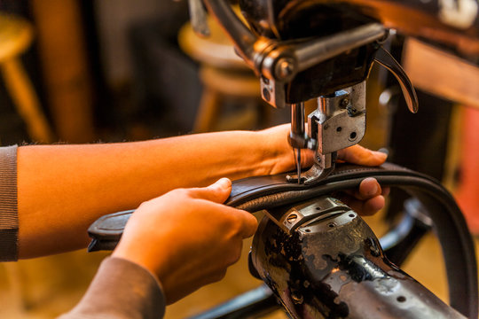 Woman sewing leg loops for a vaulting belt in saddlry