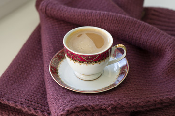 A Cup of coffee on a burgundy canvas