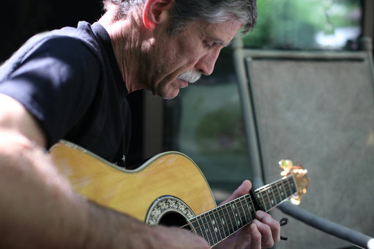 An Older Man Playing Guitar.