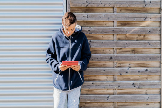 Teenager looking his tablet on the street