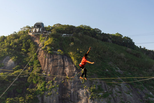Slackliner walking on highline with Sugar Loaf Mountain on the back