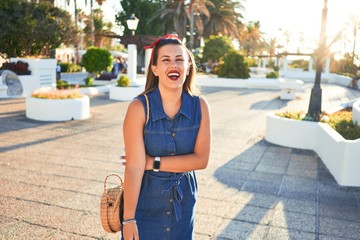 Young beautiful woman smiling happy walking on city streets of Puerto de la Cruz, Tenerife on a sunny day of summer