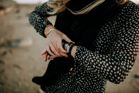 woman holding mala bracelets on the beach