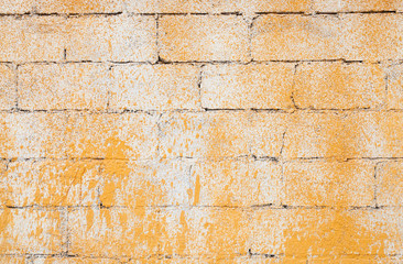 Old brick wall with yellow paint, background texture