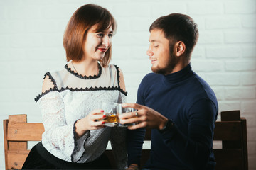 Young couple guy and girl drink whiskey on a date