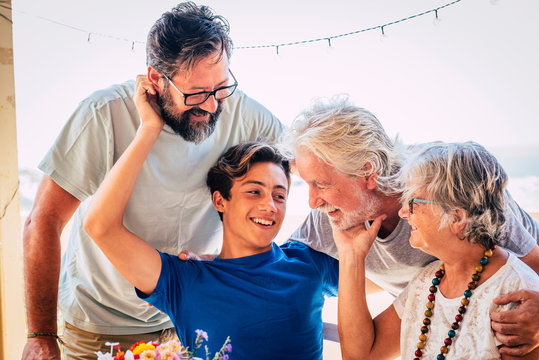 Family caucasian portrait of happy cheerful family with three generations from grandson to son and grandfathers all together having fun and love - concept of mixed ages and friendship