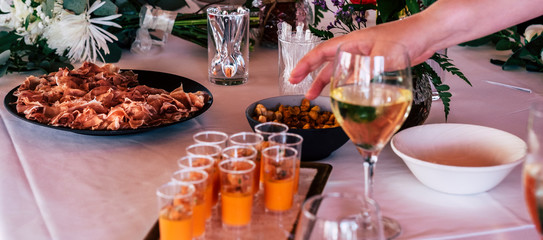 Unrecognizable people hand taking some food from a table - catering and event concept