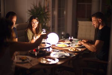 Beautiful family on dinner talking and smiling at terrace
