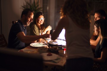 Beautiful family on dinner talking and smiling at terrace