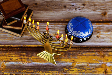 Hanukkah celebration with menorah with wooden dreidels and candles
