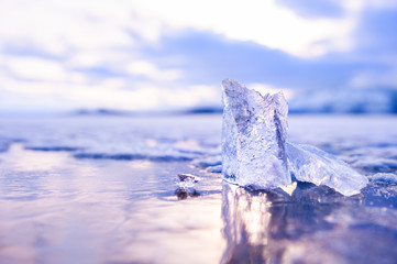 Ice on the frozen lake at sunset. Macro image, shallow depth of field. Winter nature background