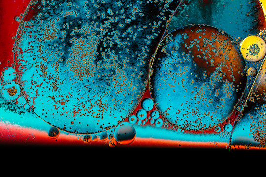 Macro shot of water oil emulsion over colored background