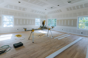 Finishing putty in the room walls plasterboards with room under construction