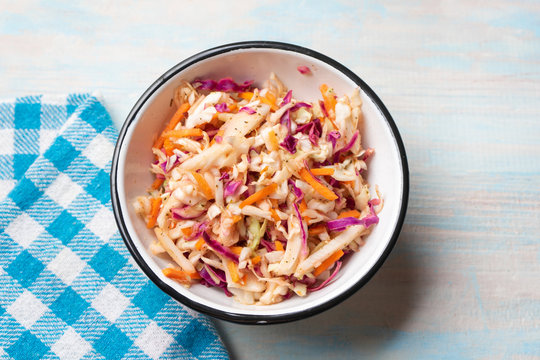 Coleslaw with vinegar and oregano on wooden background