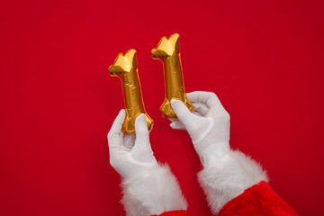 12 days of christmas. Santa hands holding 11th day balloon on red background