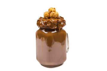 Chocolate milkshake with whipped cream, cookies, waffles, served in glass mason jar. 