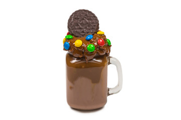 Chocolate milkshake with whipped cream, cookies, waffles, served in glass mason jar. 