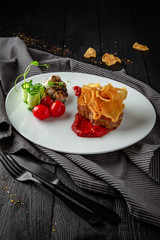 Beef steak mignon with spicy sauce, chips, vegetables. Restaurant menu. Background black boards.