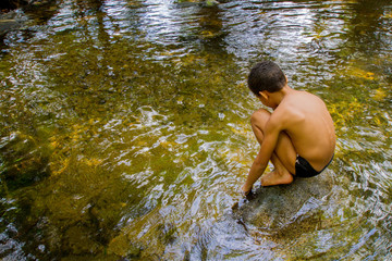 A 7-year-old boy plays in a river in Itatiaia National Park in the Mata Atlantica biome. Rio de janeiro Brazil