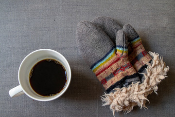 Fototapeta na wymiar Cozy warm winter gloves and cup of coffee