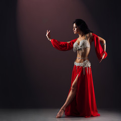 beautiful girl in red ethnic dress dancing oriental belly dance