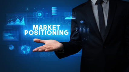Hand of Businessman holding MARKET POSITIONING inscription, business success concept