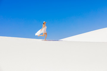 Woman walking across Gypsum Sand Dune, White Sands, New Mexico