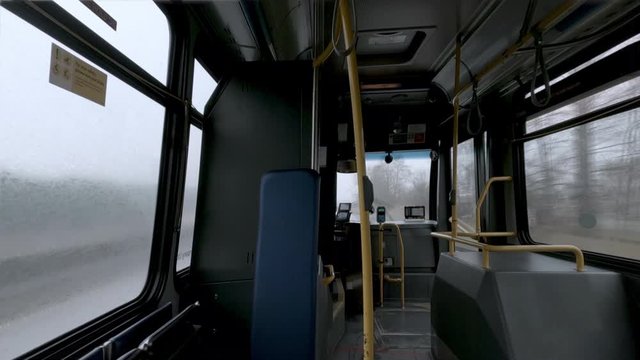 view from an empty passenger bus interior moving in rainy, foggy day