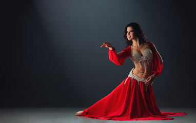 Woman in red arabic dress dancing oriental dances in stalls