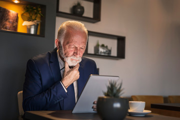 Fototapeta premium Senior businessman working on a tablet computer