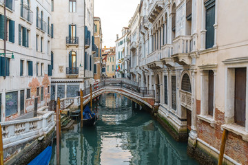 Naklejka na ściany i meble Boats on narrow canal between colorful historic houses in Venice.