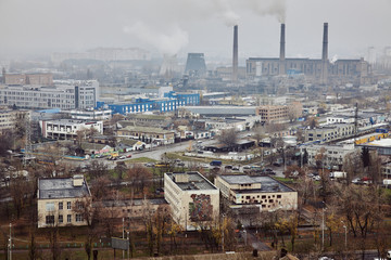 The aerial View of urban fringes in foggy day.View over the city rooftops at industrial suburb.Heating Power Plant,moderns buildings,uptown