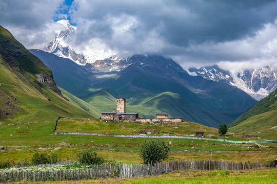 View of the Ushguli village at the foot of Mt. Shkhara. Lamaria Monastery, old Rock tower.
