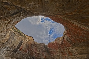 Looking through the hole in the roof at the sky from within Devils Punchbowl Oregon