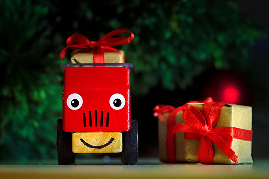 Red Children's Toy Car With Gift Boxes With A Red Bow Under The Christmas Tree