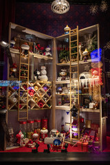 Shiny colorful showcase decorations at Christmas time in Europe. Abstract background. Night city life. Blurry reflections in shop window glass with night lights.