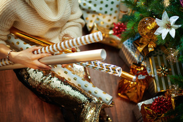 stylish 40 year old woman holding wrapping paper rolls