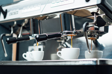 extraction of espresso from a bottomless portafilter in white cups