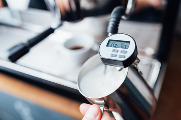 measuring the temperature of milk foaming with steam under pressure from a coffee machine