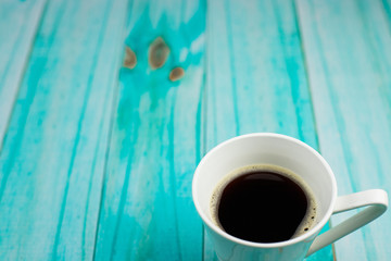 Czarna kawa na turkusowym stole - obrazy, fototapety, plakaty