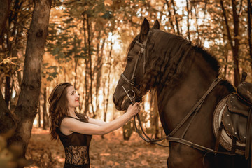 Vintage photo, elegant woman in black dress with a horse